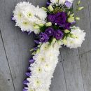 Cross in white chrysanthemums with purple corsage
